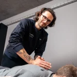 Fizjoterapeuta Pracowni Ruchu pracuje manualnie z klientem podczas pierwszej wizyty.